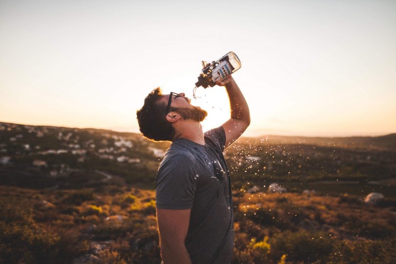 Man Pouring Water Bottle on His Mouth