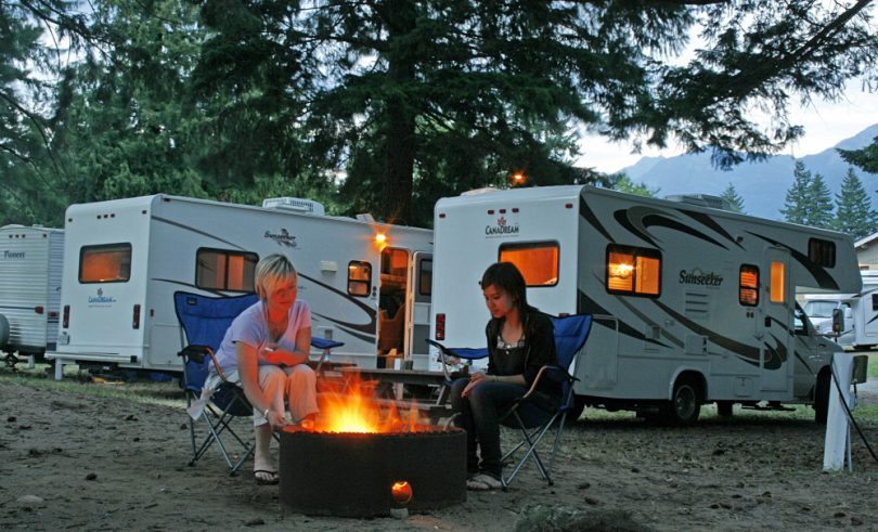 two womens sitting around a campfire