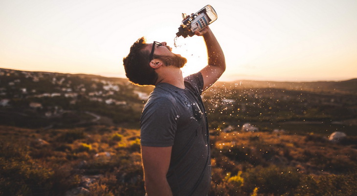 Man Pouring Water Bottle on His Mouth