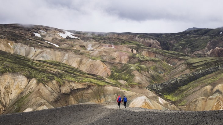 2 People Walking Towards the Mountain during Daytime