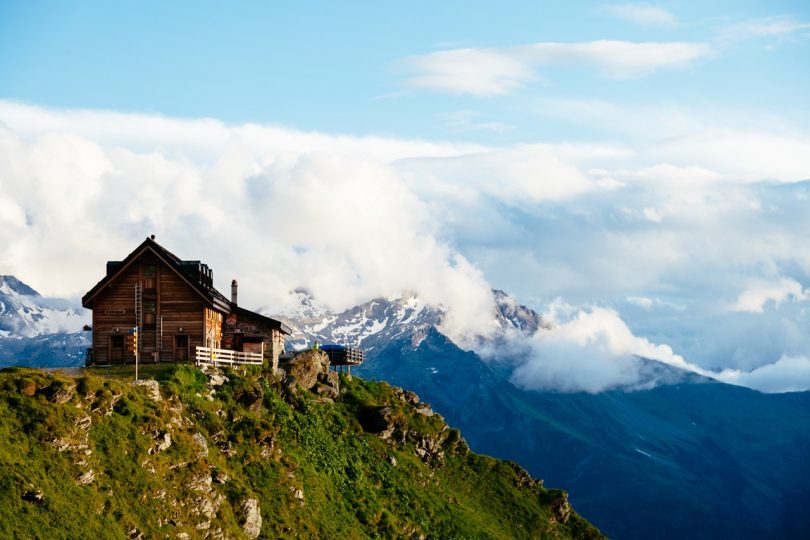 Photography of Brown Wooden House Top of Mountain Under White Sky during Daytime