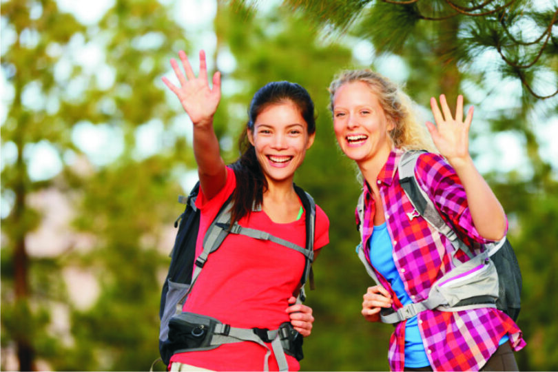 women say hello to other hikers