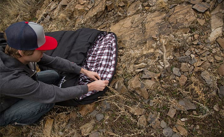 A boy looking down to Teton Sports Deer Hunter sleeping bag