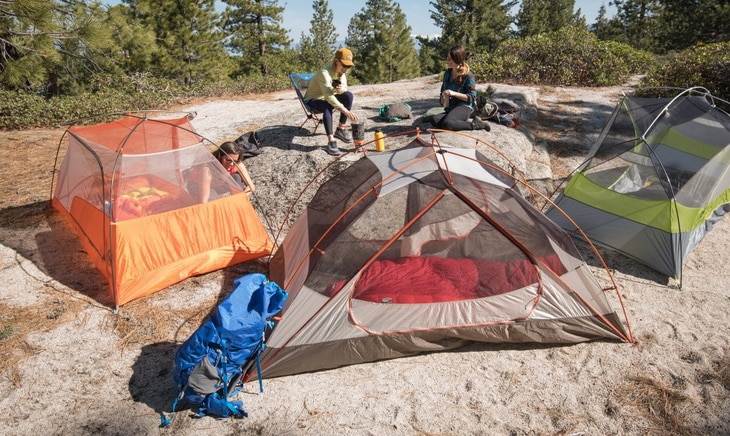 Three womans and three tents in the forest