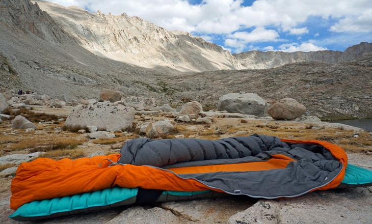 A sleeping bag and a mountain landscape in the background