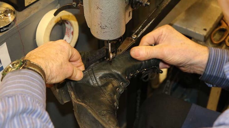 Brian stitching in a zip in a boot