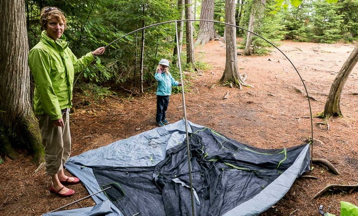 A mother and a child setting up a tent