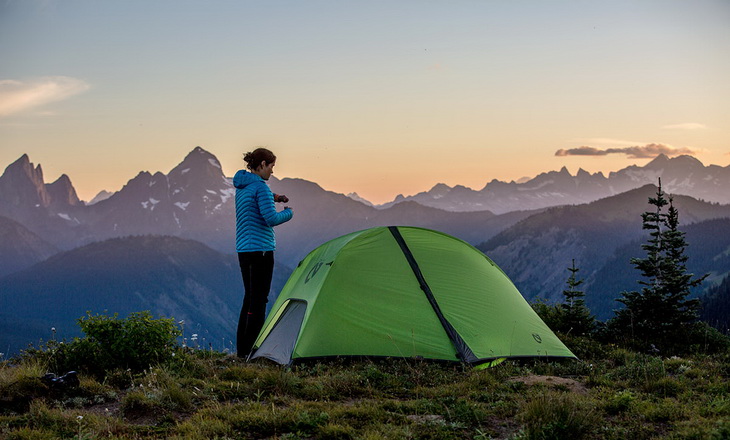 A woman near Nemo Hornet 2P tent camping in the wild
