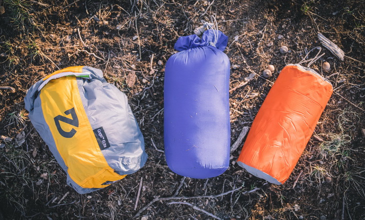 Nemo next to another 2 sleeping bags in storage sacks