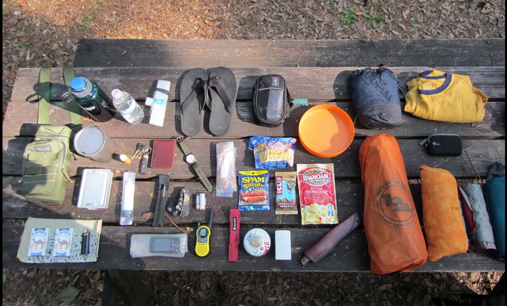 backpacking gear on a wooden table outside