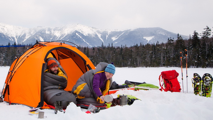 Two adults in Nemo Sonic Down Sleeping Bags camping in the winter