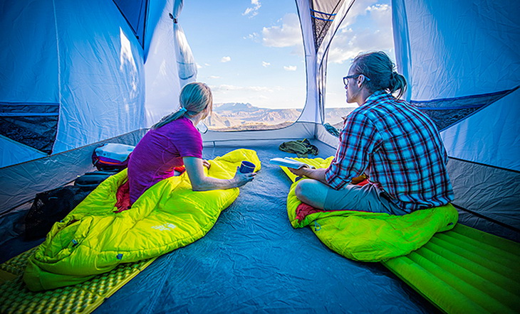 Two adults in Mountain Hardwear HyperLamina Spark 35 Sleeping Bags looking at the landscape