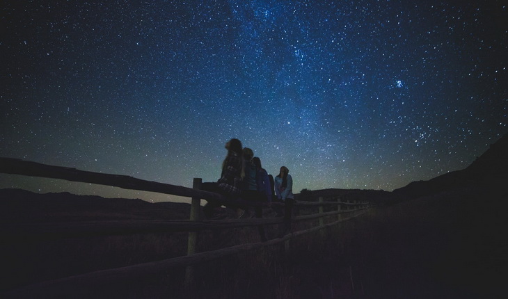Group of People Sitting on Wooden Farm Fences Star Gazing