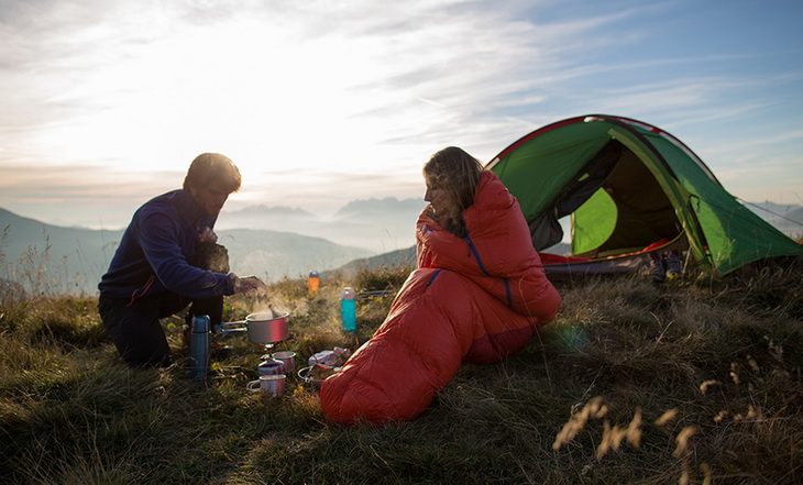 Two hikers on the mountains preparing cofee in the morning