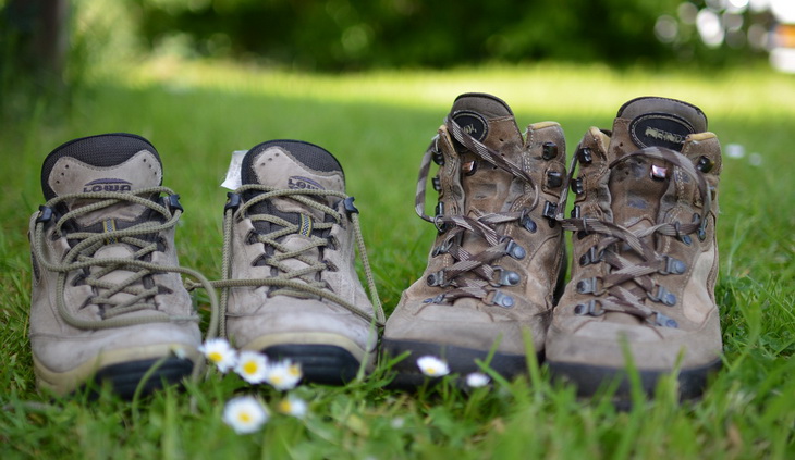 Two pairs of hiking boots on the grass