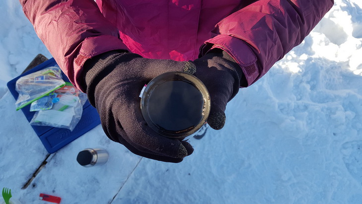 Hot liquid thermos in hand of a man