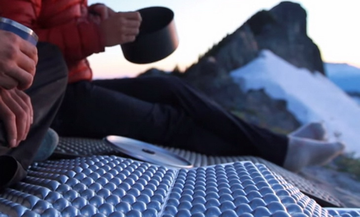 Two adults sitting on Therm-a-Rest Z Lite Sol Mattress in the winter time outside