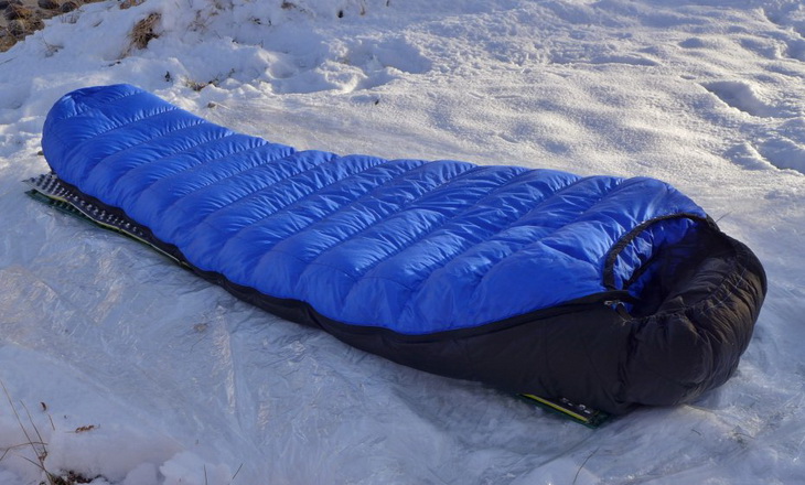 Western Mountaineering Ultralite Mummy Sleeping Bag laying on the snow