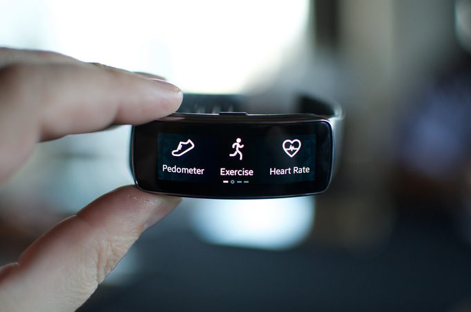 A person holding a Samsung Gear smartwatch
