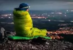 a man in sleeping bag watching over the city