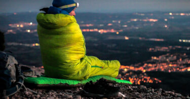 a man in sleeping bag watching over the city