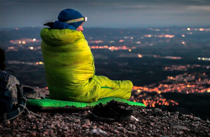 a man in sleeping bag watching over the city