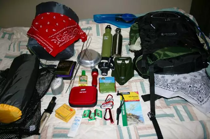 backpacking gear on bed