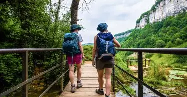 Couple wearing backpacks on a bridge