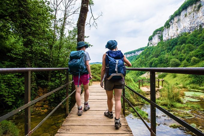 Couple wearing backpacks on a bridge