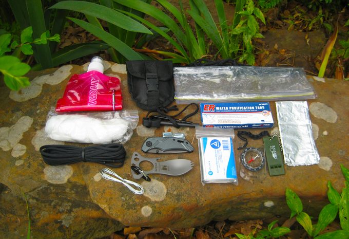 survival kit laid out on rock