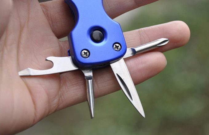 man holding a keychain multi tool in hand