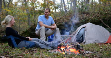 Alps Mountaineering lightweight backpacking tent and two adults next to him