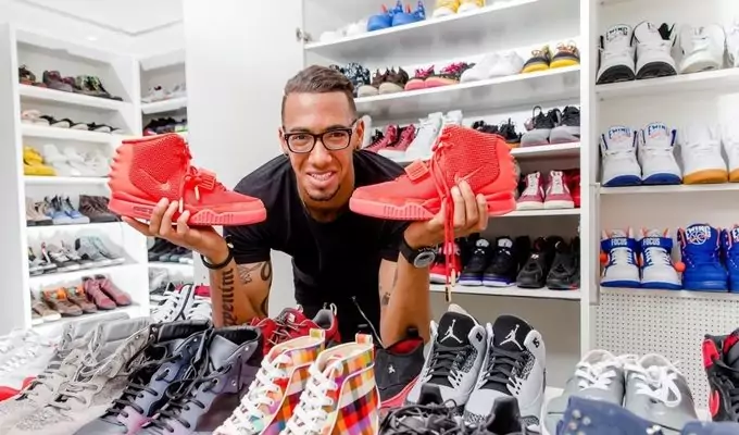A man in a shoe store holding a pair of sneakers