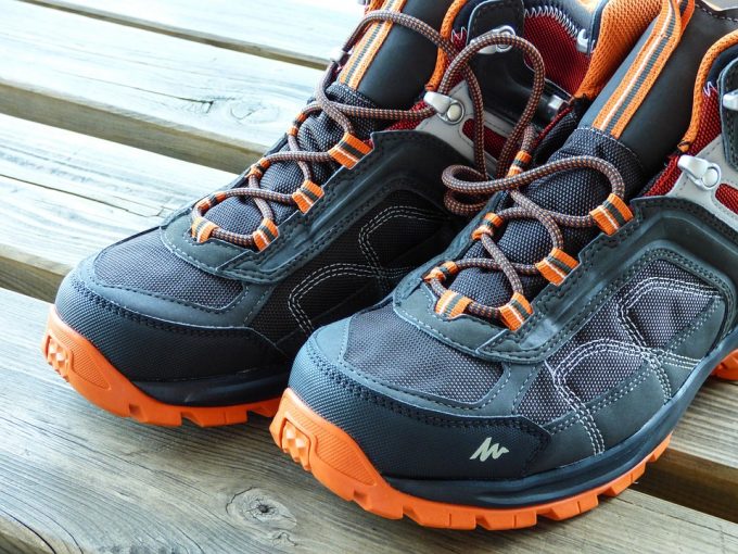 black and orange hiking shoes on wooden table