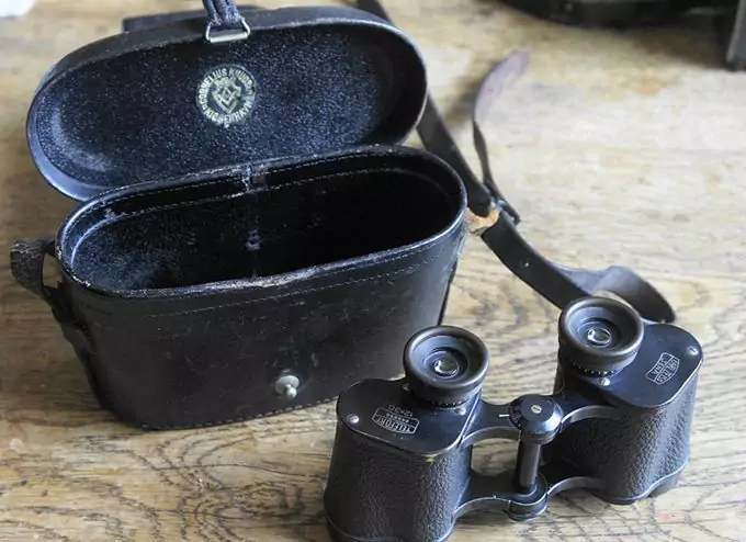 compact binoculars with housing on table
