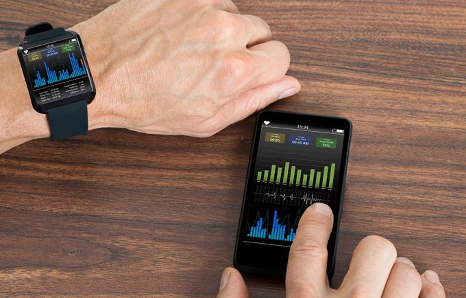 Man With Smartwatch And Cellphone Showing Heartbeat Rate