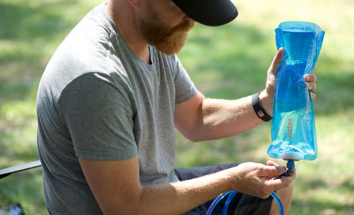 A man holding a Vapur water bottle