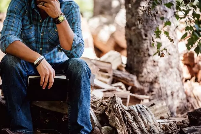 man in the woods wearing survival watch
