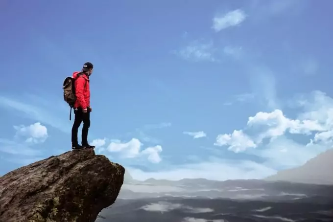 A hiker with red colored jacket on a hilltop