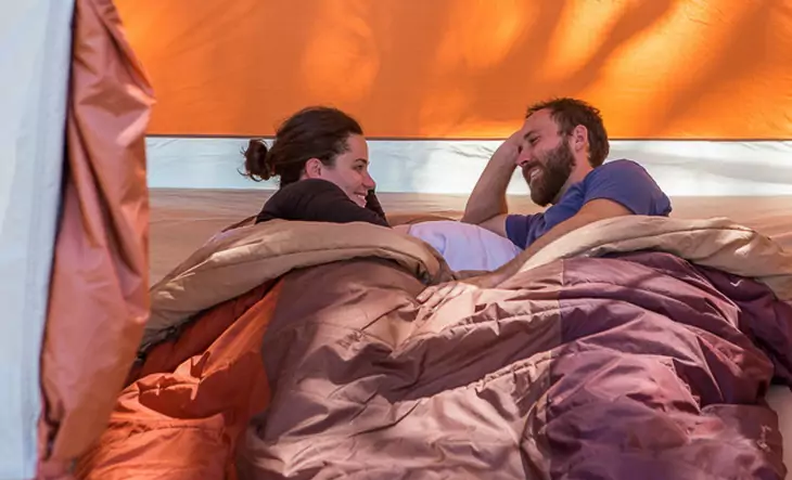 A couple sharing The North Face Dolomite 3S sleeping bag in a tent