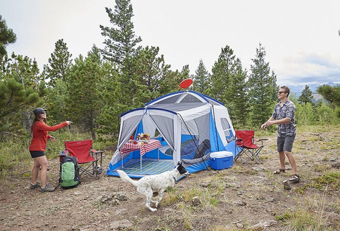 couple camping and playing Frisbee