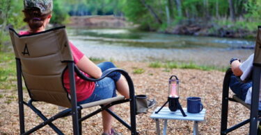 Woman relaxing in Alps Mountaineering King Kong Chair is looking at the river