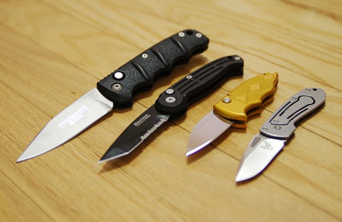 collection of folding knives on table 