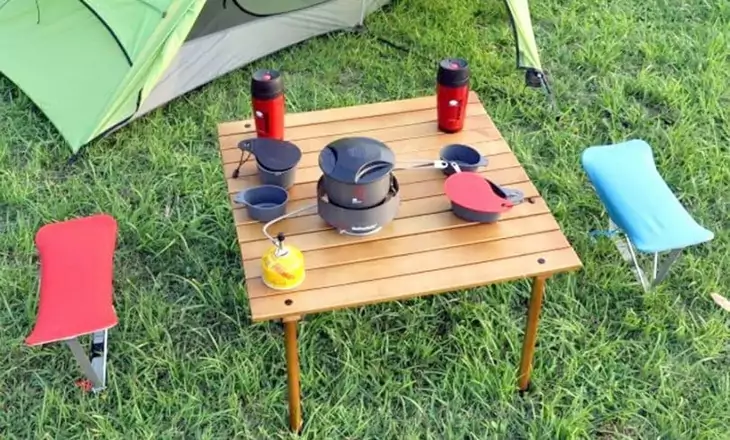 A folding table near a tent in the campsite