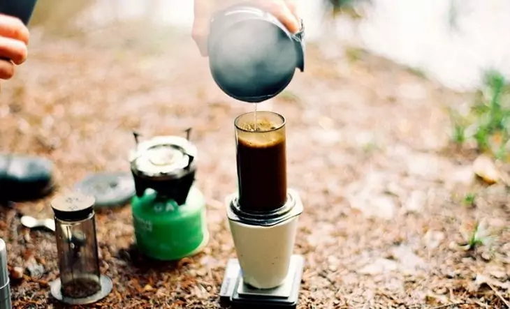 Image of a person making coffee in camp with a coffee maker