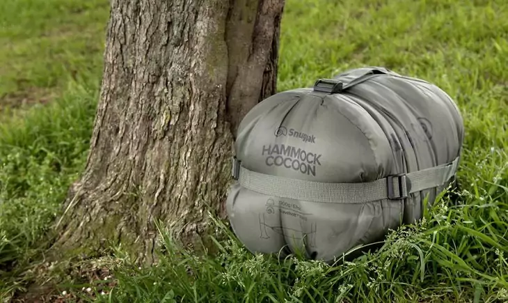 Compression-sack-for-a-sleeping-bag near a tree