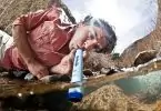 A man drinking water from the LifeStraw Water Purifier wich is the Lightest Backpacking Water Filter