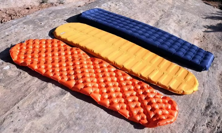 Types of sleeping pads on the ground outside in the sun
