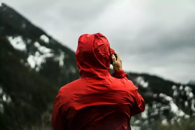 man taking a photo and wearing rain jacket