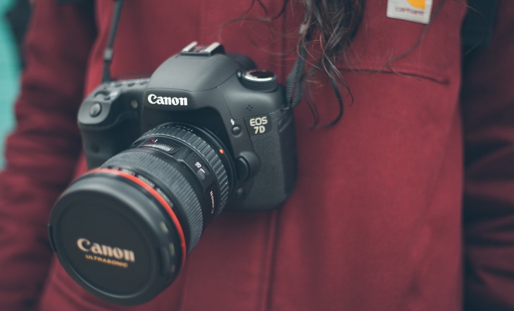 a woman carrying a Canon hiking camera